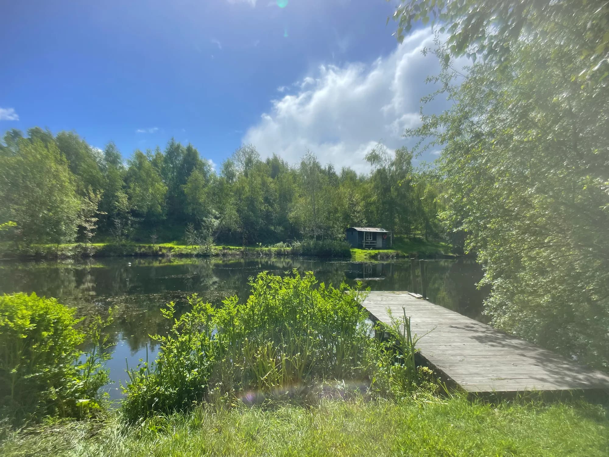 View over the private lake and surrounding hills at Garth Barns